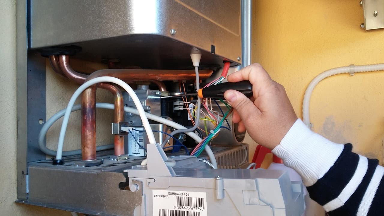 Engineer testing the inside of an open gas boiler